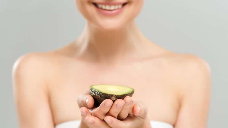 Woman on beauty diet holding avocado