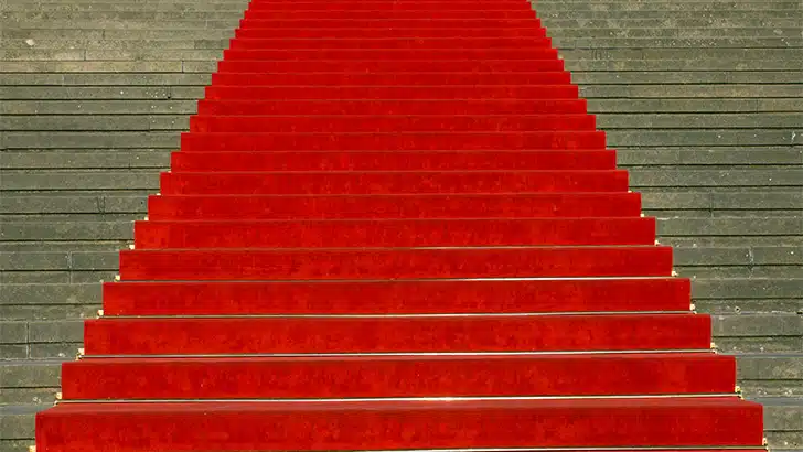 Red carpet running up stairs outside.