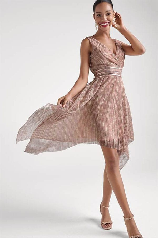 Smiling model twirls while wearing a sequin dress. 
