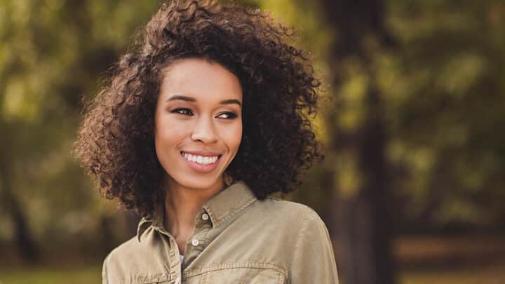 Adult woman with healthy curly hair thanks to natural hair care ingredients.