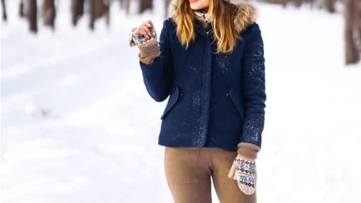 Woman wearing winter jacket outside in the snow.